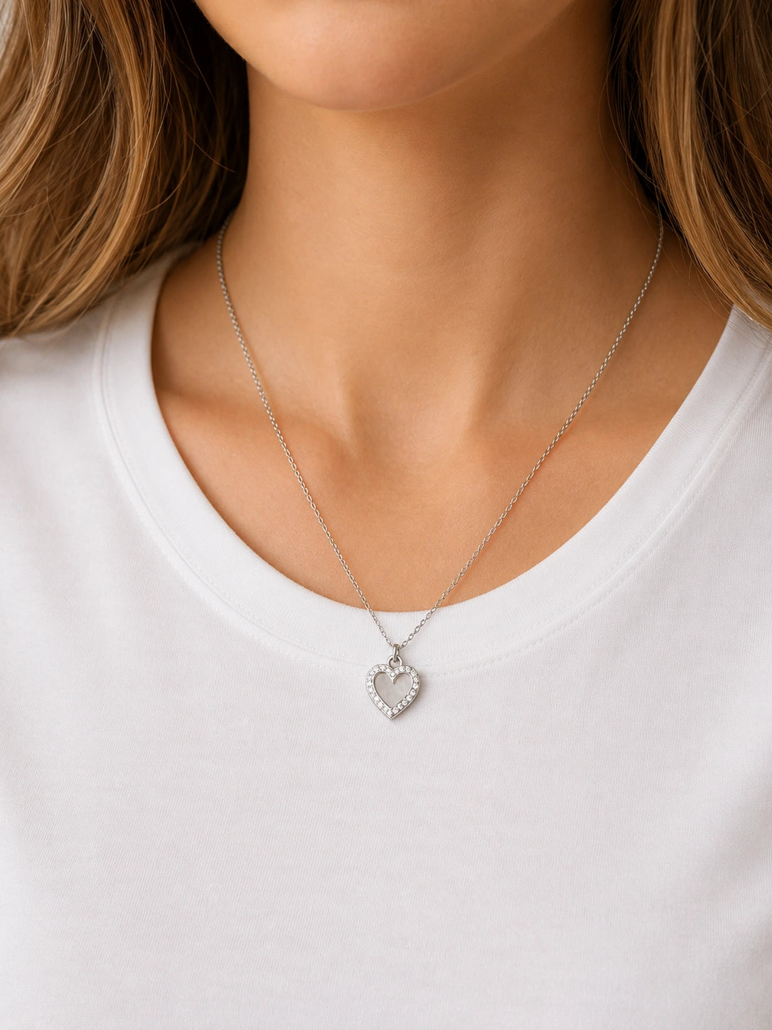 Collier cœur argenté avec strass en acier inoxydable porté par une femme