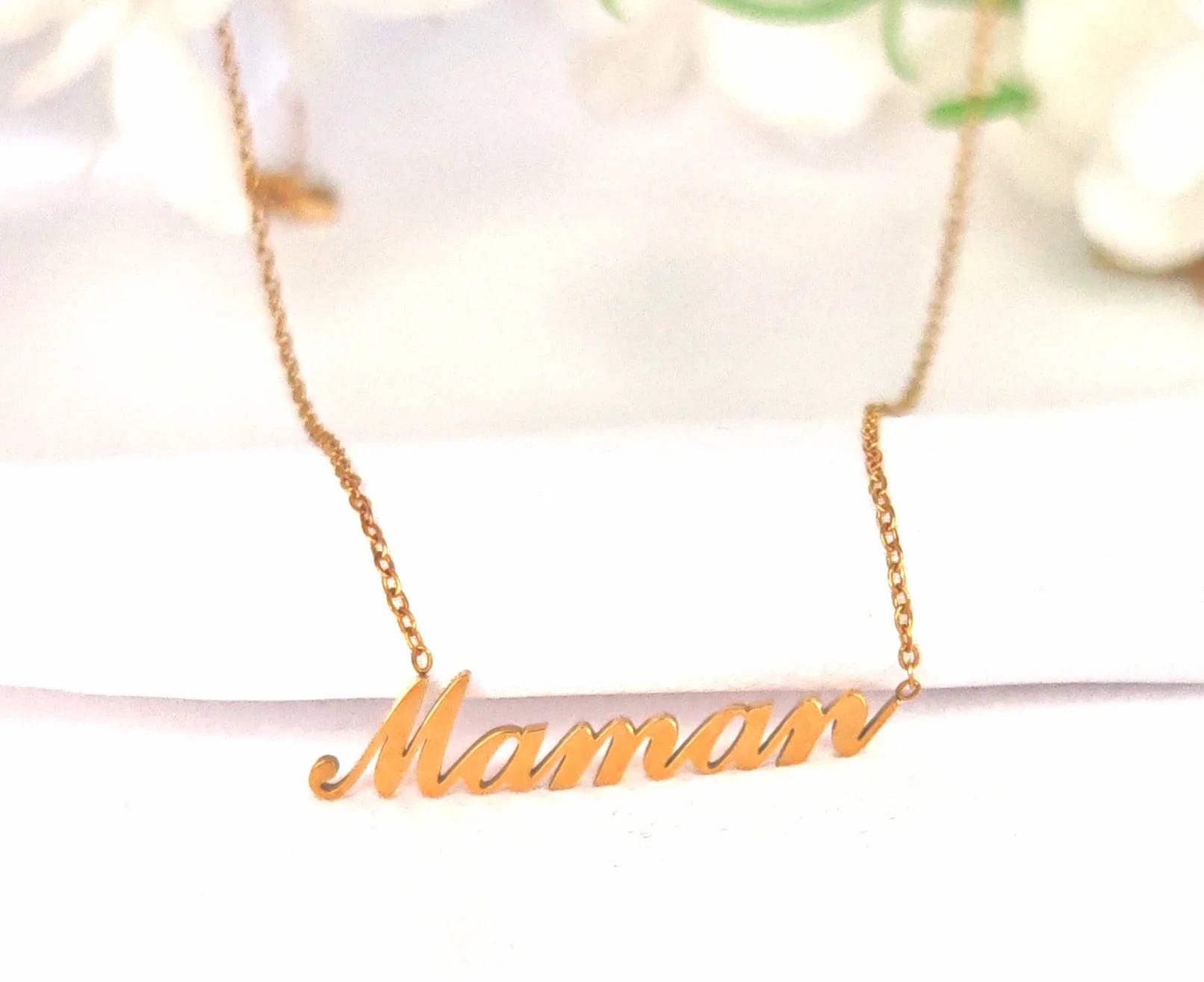 🌸 Un mot doux, porté près du cœur
“Maman” — un mot simple, mais chargé d’émotions et de souvenirs. Ce bijou en est l’écho précieux.

Ce collier pour maman en acier inoxydable incarne l’amour maternel avec élégance. Son pendentif délicatement découpé affiche le mot “maman” dans une écriture fluide, féminine et intemporelle. Sa finition dorée ou argentée selon le modèle, alliée à la solidité de l’acier, en fait un bijou à porter chaque jour, en toute simplicité.
