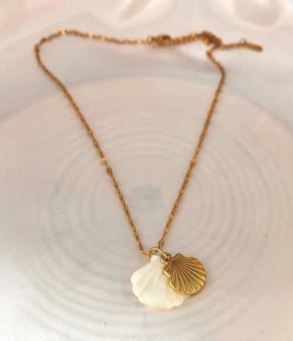 🌊 Un design naturel et raffiné

Ce collier délicat se compose d’une chaîne en acier inoxydable ornée d’un pendentif en forme de coquillage, subtilement nacré. Ses reflets doux et lumineux apportent une note chic et intemporelle, parfaite pour sublimer aussi bien une tenue estivale qu’un look de tous les jours.
Waterproof, hypoallergénique et durable, il est conçu pour résister à la vie quotidienne sans perdre son éclat.

C’est le bijou idéal pour les amoureuses de la mer et des accessoires minimalistes ave