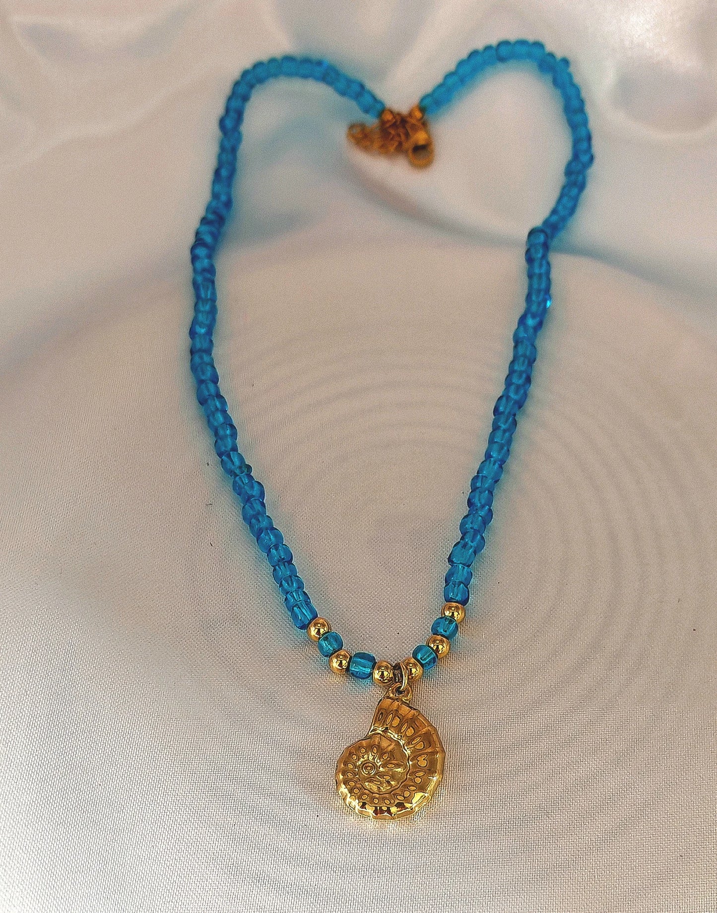 🌊 Un design élégant inspiré de l’océan
Ce collier raffiné est composé d’une chaîne en acier inoxydable ornée d’un pendentif en forme d’escargot de mer, subtilement accompagné de petites perles bleu océan qui rappellent la fraîcheur et la profondeur des lagons.

Son style marin chic s’accorde parfaitement avec une tenue estivale ou un look bohème.
Waterproof, hypoallergénique et résistant, ce bijou est conçu pour vous suivre sans s’abîmer, même sous le soleil et au bord de l’eau.