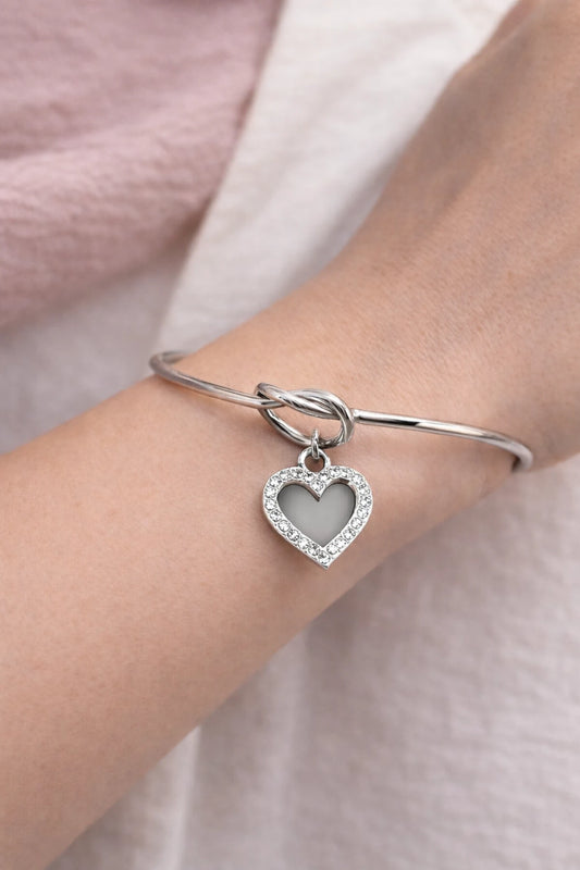 n jonc en acier inoxydable argent orné d’un cœur strassé, symbole d’amour et d’élégance intemporelle.