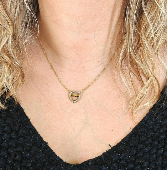  Un mot, un cœur, un éclat d’amour
Parce qu’il n’y a rien de plus précieux qu’une maman, ce bijou le dit avec élégance.

Ce collier maman célèbre l’amour maternel avec raffinement. Le mot “MAMAN” est délicatement gravé et accompagné d’un cœur orné de strass étincelants, pour une touche lumineuse et symbolique. Conçu en acier inoxydable, il allie brillance et résistance, pour un bijou à porter tous les jours, sans perdre de son éclat